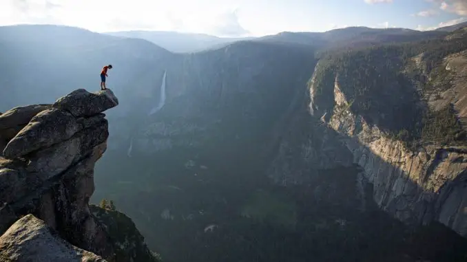 Alex Honnold schaut über den Rand des Glacier Point im Yosemite Nationalpark. Er hat gerade einen Aufstieg von über 600 Höhenmetern bewältigt